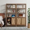Tall wooden rattan bookshelf with cabinet doors, styled in a modern living room. Aesthetic craft