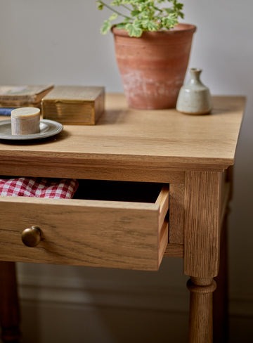 bedside table in natural pine wood with slim drawer, brass hardware, and bottom shelf