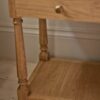 bedside table in natural pine wood with slim drawer, brass hardware, and bottom shelf