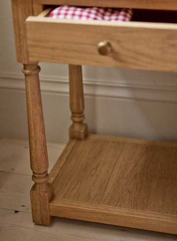 bedside table in natural pine wood with slim drawer, brass hardware, and bottom shelf