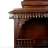 puja temple in dark brown finish with detailed carvings and dangling brass bells