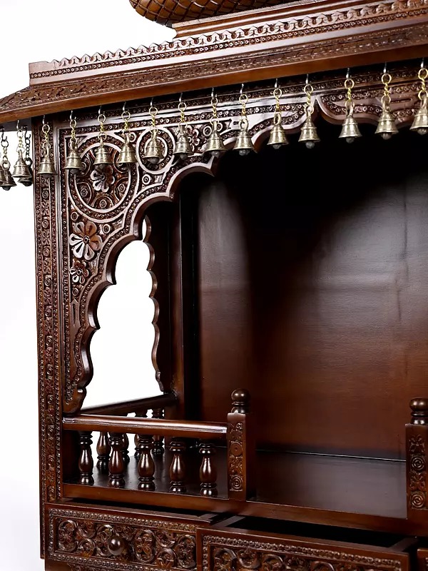 puja temple in dark brown finish with detailed carvings and dangling brass bells