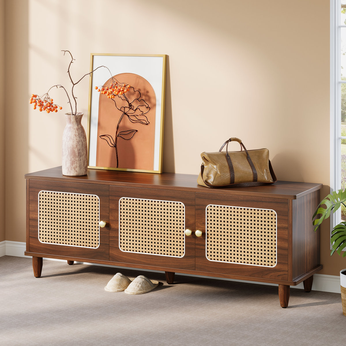 Walnut shoe storage bench with gold‑tone knobs and rattan door panels in a mid‑century modern style