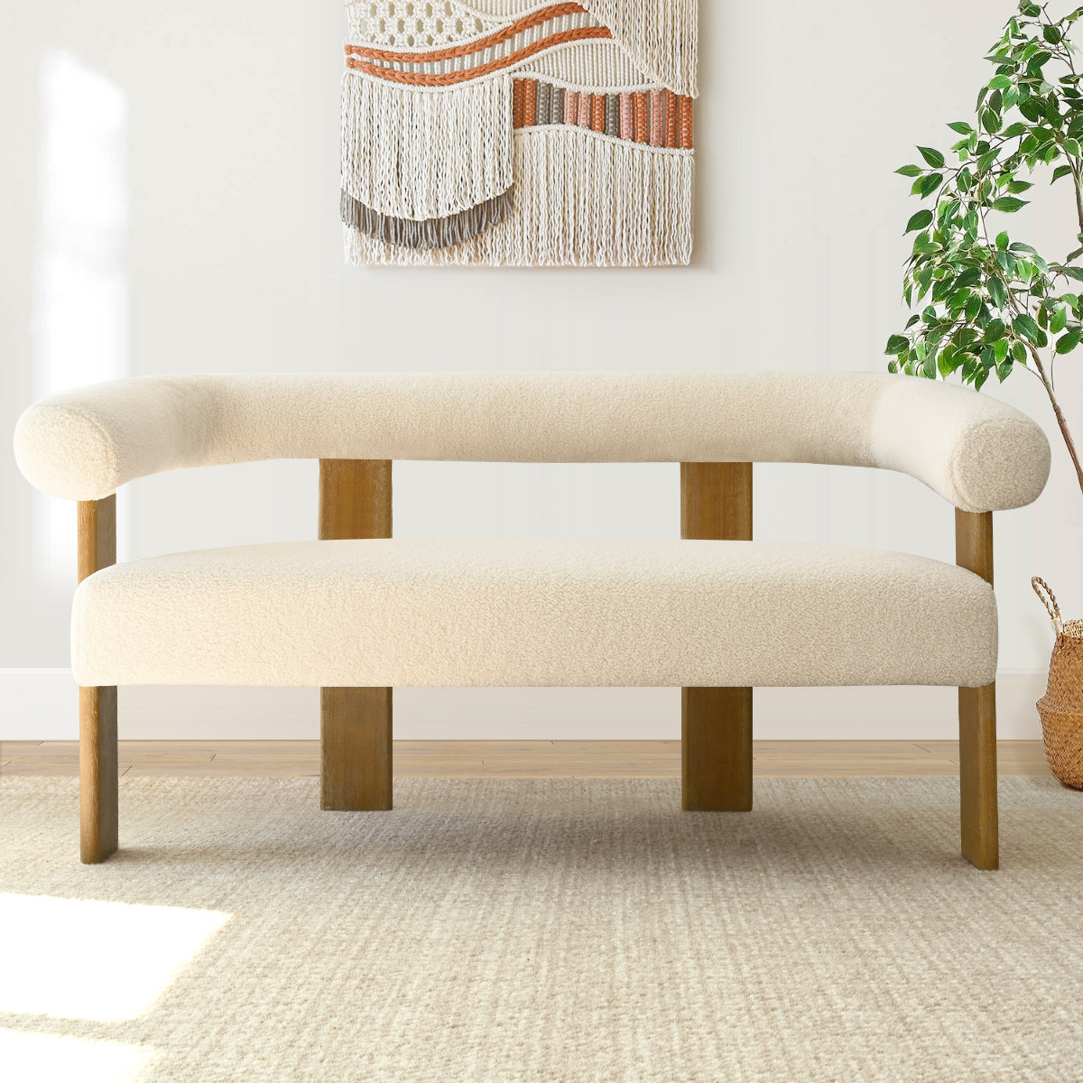 Mid-century style teak wood loveseat with soft boucle fabric upholstery, rounded arms, and splayed legs in a neutral setting.